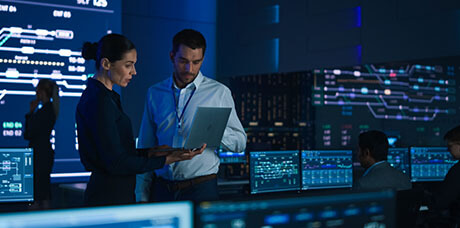 man and woman monitoring cyber security